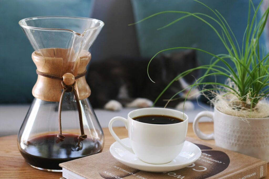 a cup of coffee and a book on a table - Coffee-to-Water Ratio